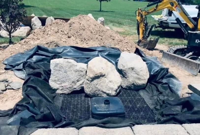 Liner, AquaBlox reservoir, and staged boulders during a pondless waterfall build